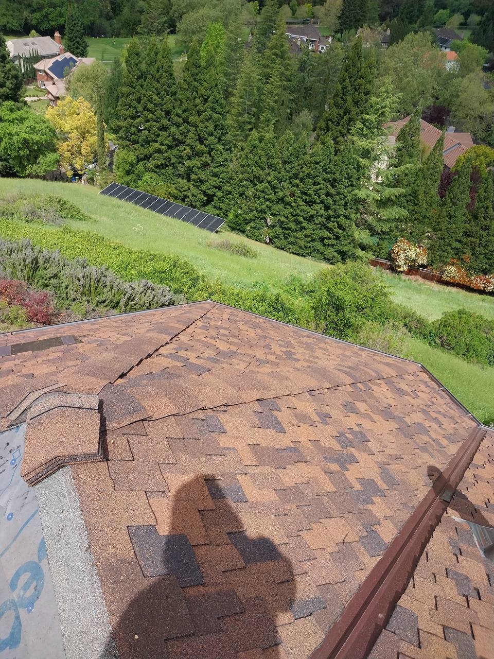 Close aerial of finished roof valley with landscaped garden backdrop
